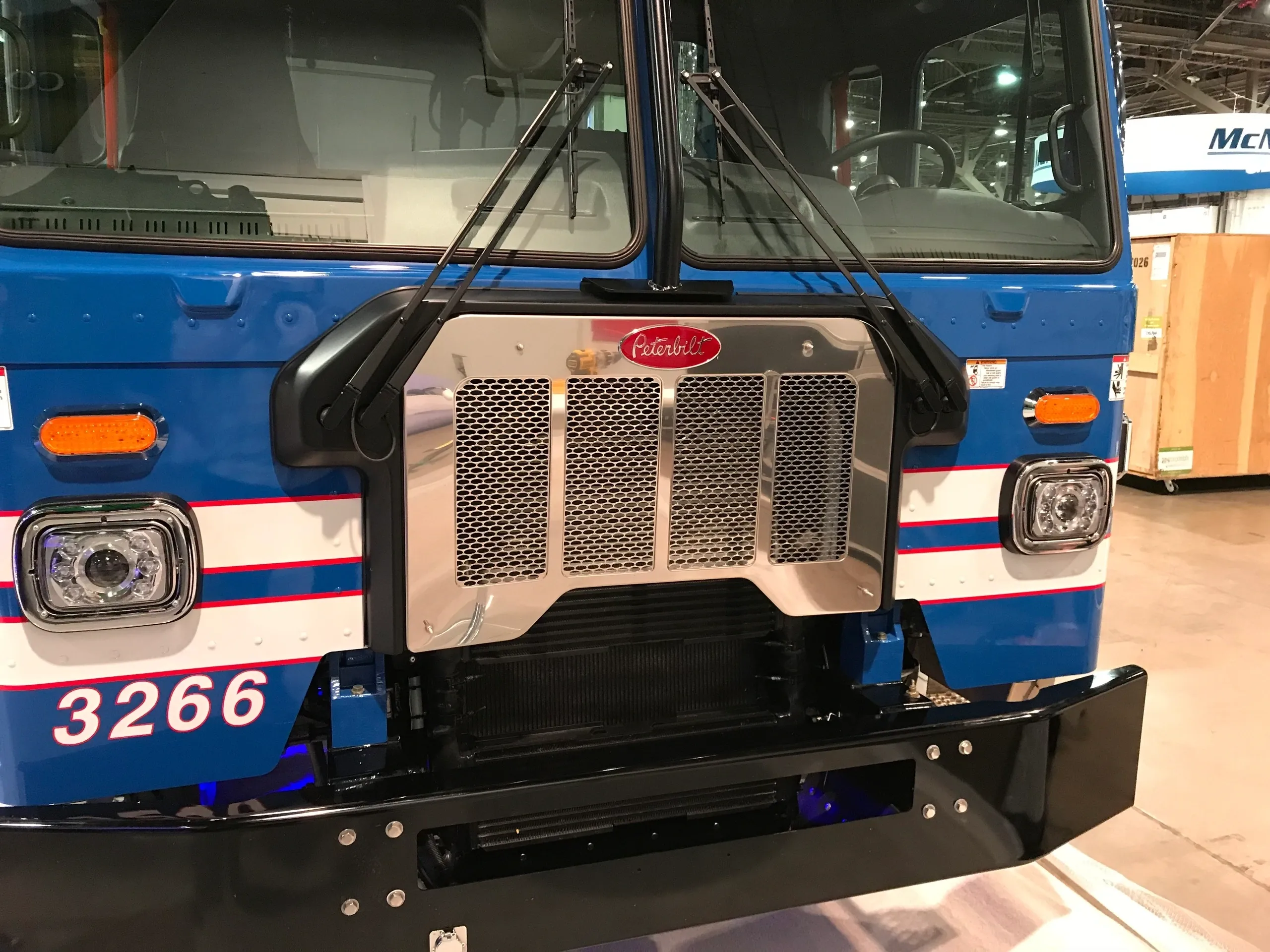 Front view of a blue Peterbilt truck with a prominent grille and headlights.