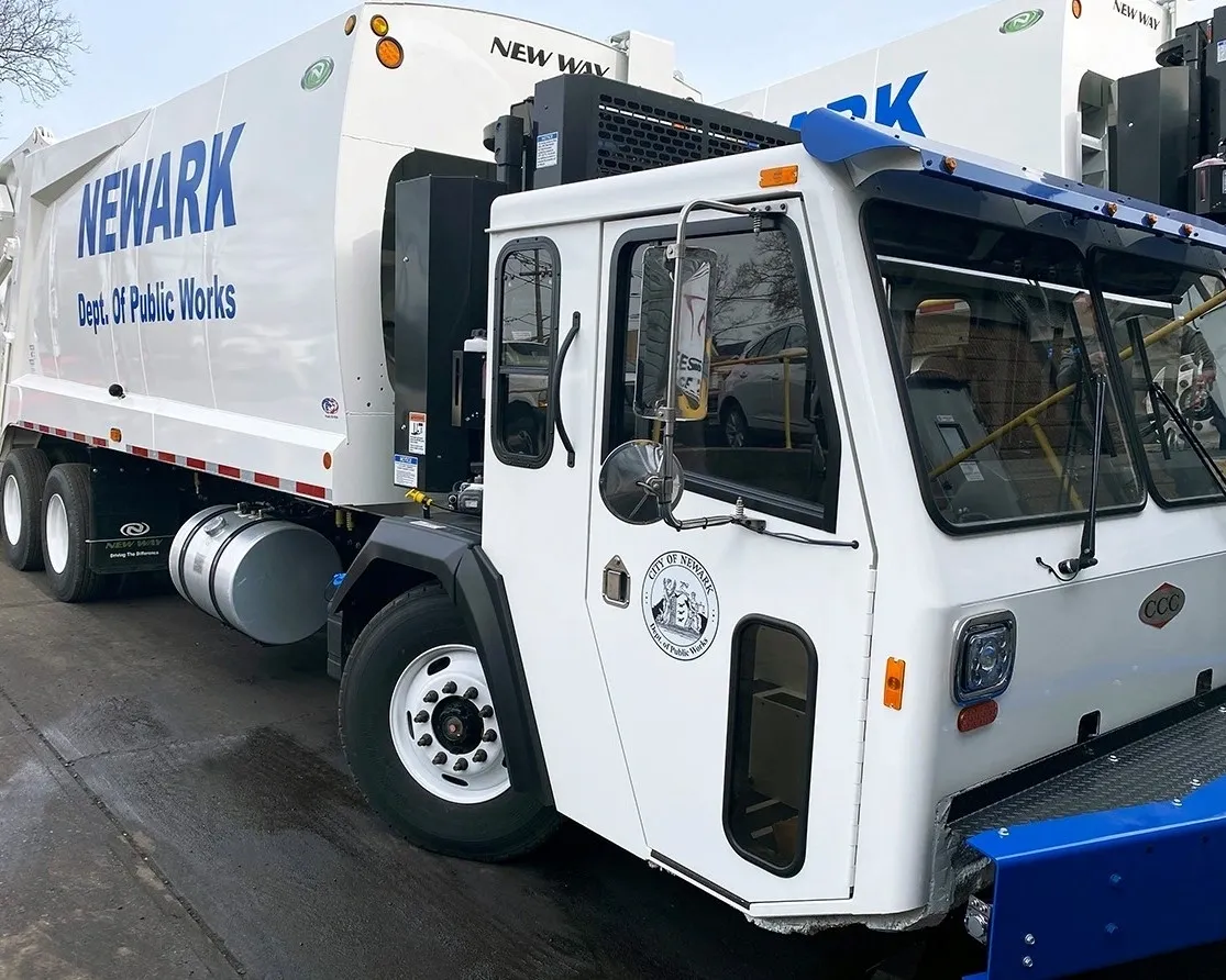 A white street cleaning truck parked on the street.