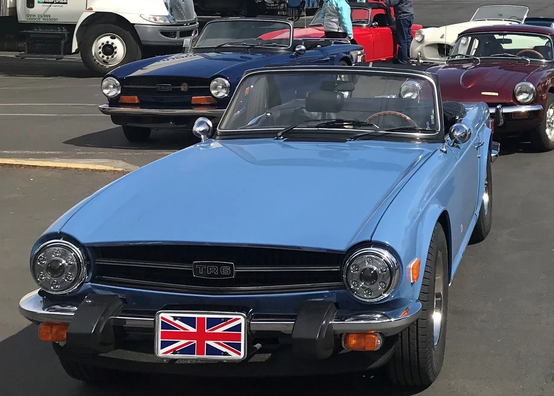 Blue vintage convertible car with a Union Jack license plate.