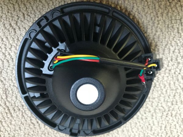 Black circular component with colorful wires attached.